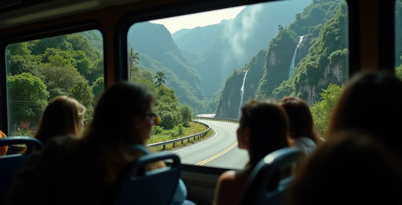 Vue depuis l'intérieur d'un bus sur la route sinueuse de Cilaos avec cascades et végétation tropicale